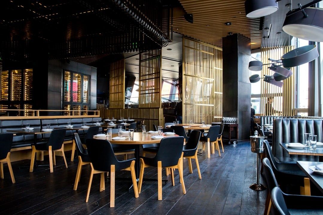 Modern restaurant dining room with tables, booths, and layered ceiling fixtures
